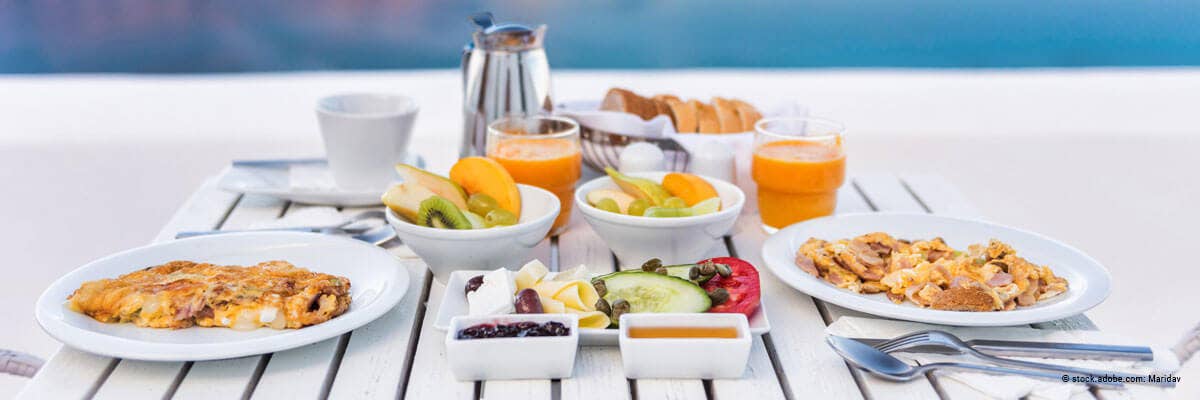 Gedeckter Frühstückstisch mit Omlette, Obst, Gemüste, Kafee und Orangensaft